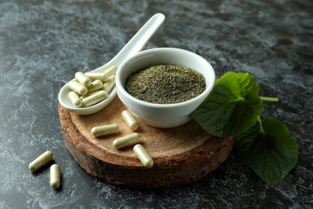 Concept of herbal medicine pills on black smokey background, close up